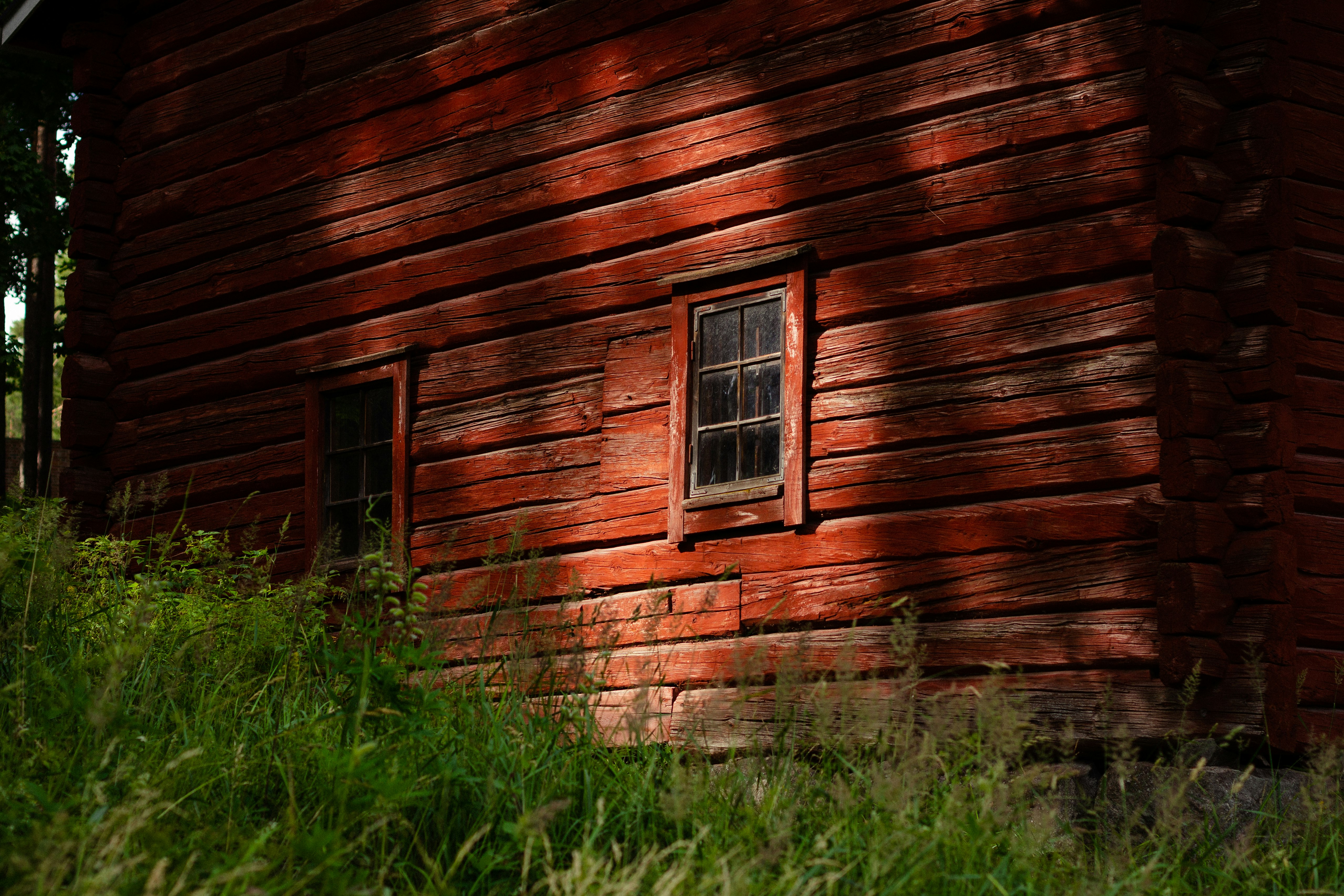 brown wooden house with green grass field